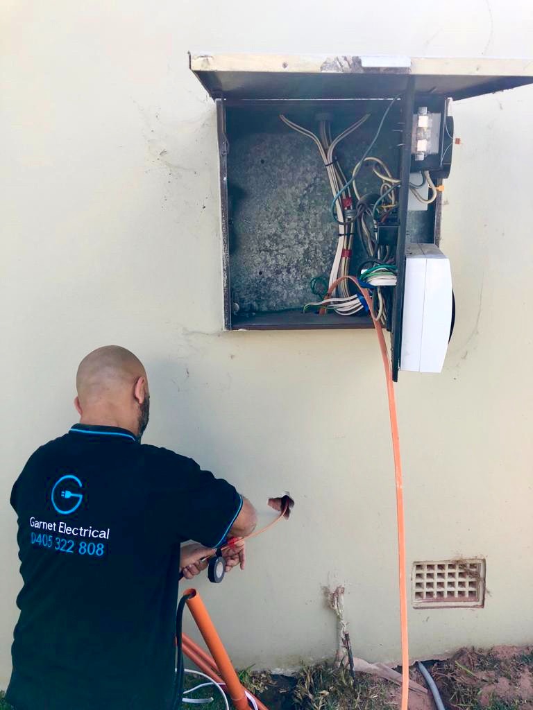 Licensed electrician working on a switchboard installation in Sydney